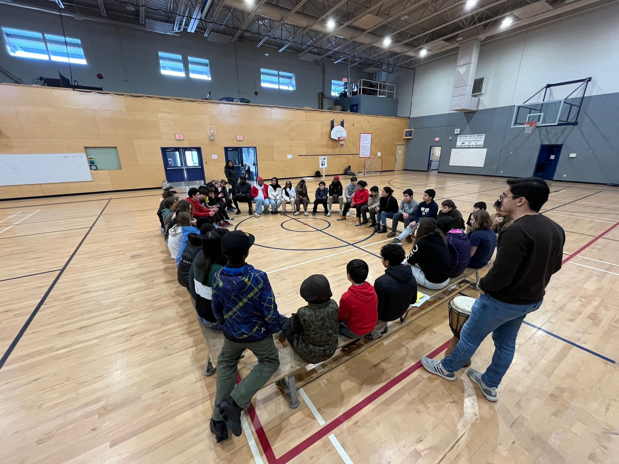 Junior youth gathered in a circle in a gym